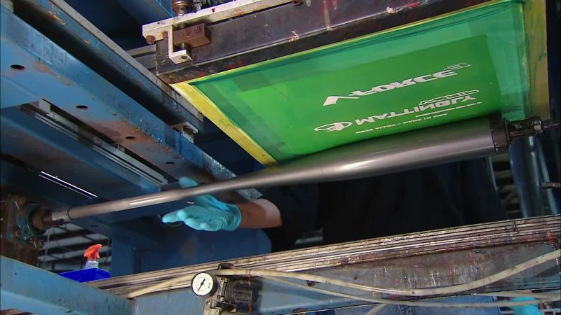 THE SANDED BATS GO INTO A SILK-SCREEN MACHINE