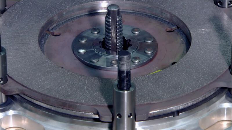 The technician places a stand over each bolt