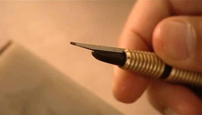 THEN HE SHARPENS ANOTHER TOOL CALLED A LOZENGE GRAVER