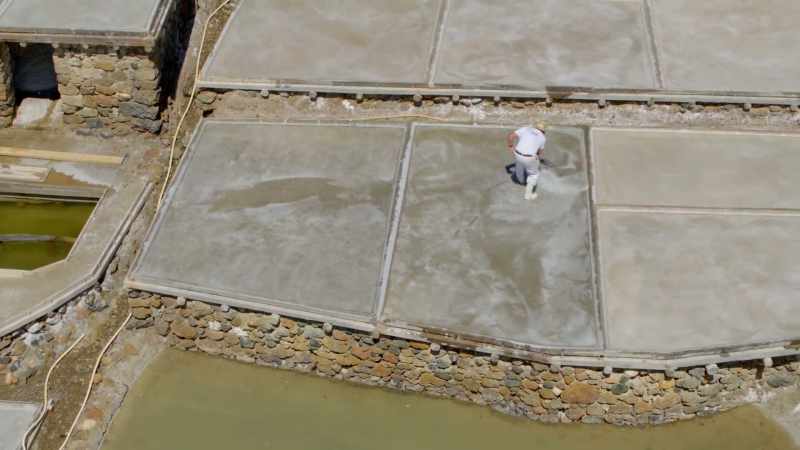 They painstakingly stir each salt pan