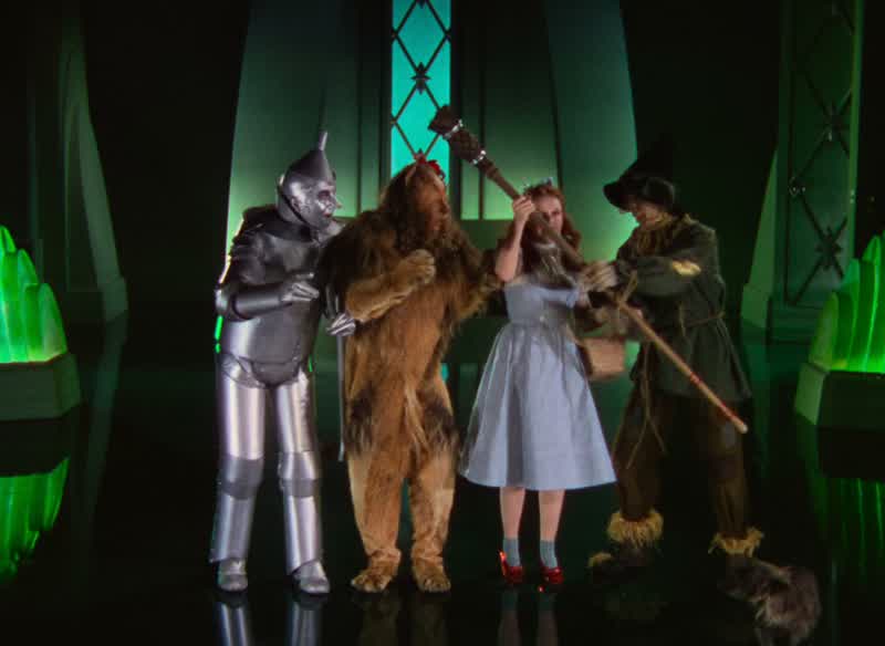 Please sir We've done what you told usWe've brought you the broomstick of the Wicked Witch of the WestWe melted herAh you liquidated her ehVery resourceful Yes sir