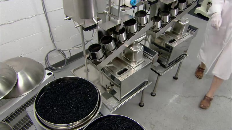 Workers empty the containers into large colanders
