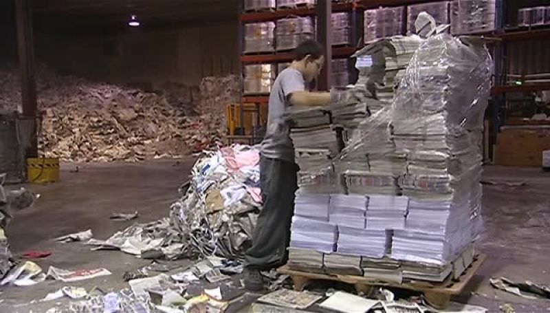WORKERS LOAD IT ONTO A CONVEYOR BELT